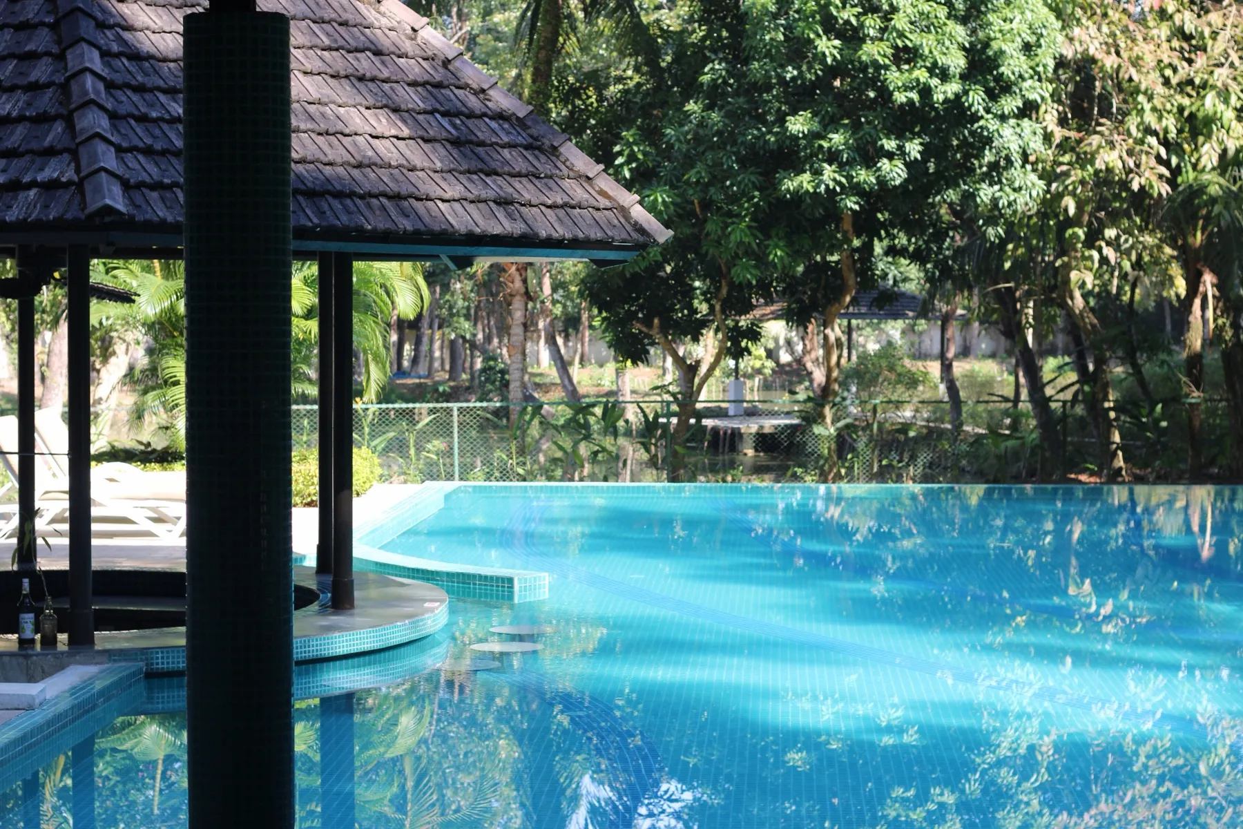 Rectangular in-ground pool beside a deck, where a solar cover reel mounts