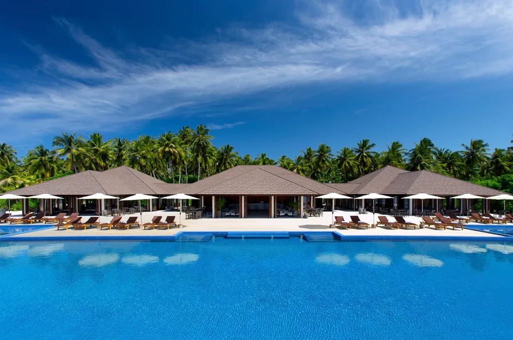 A large in-ground resort-style swimming pool with clear blue water and a paved deck