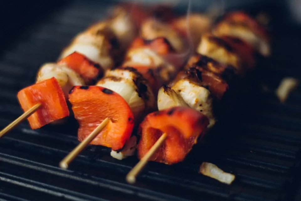 Colorful kabob skewers with peppers and onion grilling on a barbecue